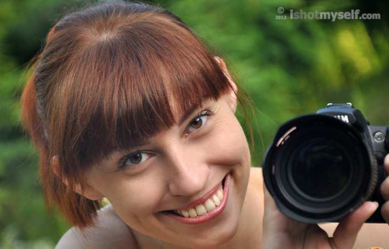 Голая девушка с фотоаппаратом на природе