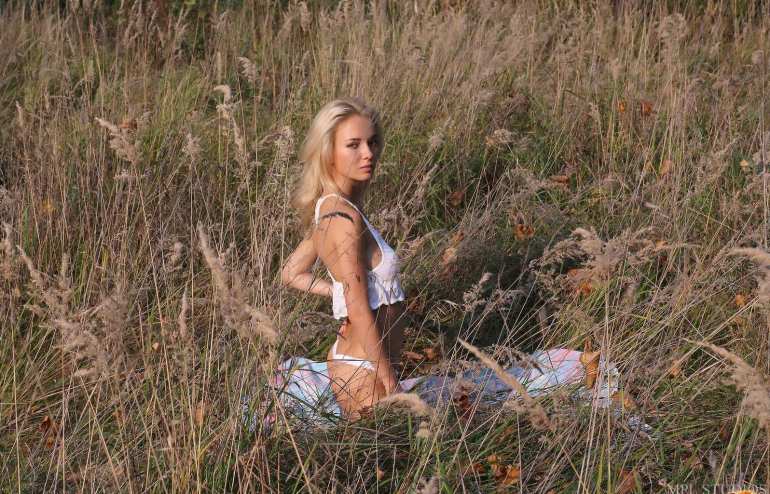 Красивая блондинка с натуральными сиськами разделась в траве