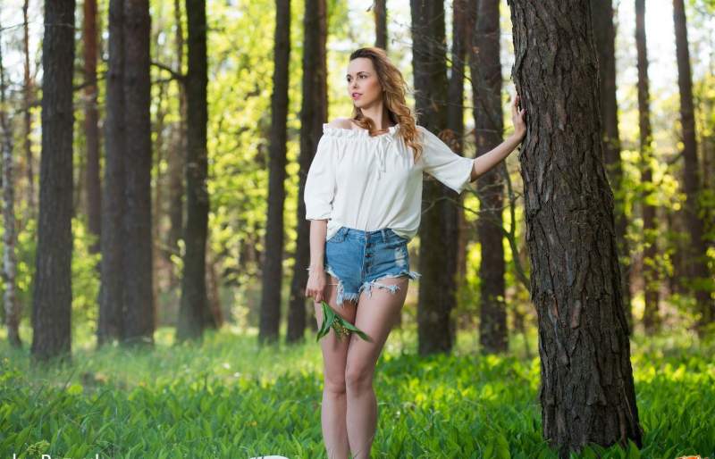 Девушка снимает шорты и показывает киску в лесу