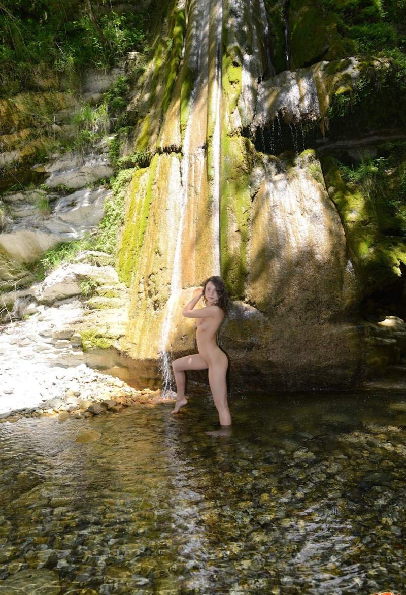 Нагая молодая красивая женщина намочилась под водопадом ✅ Фото
